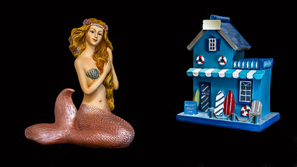 Mermaid primps outside of a beach front store.