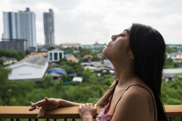 Fototapeta na wymiar Sexy Asian woman smoke cigarette on balcony