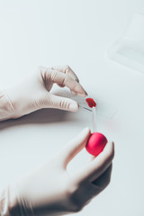cropped shot of doctor pouring blood from pipette onto blood slide