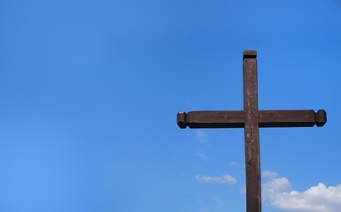 Wooden cross on a background of blue sunny sky