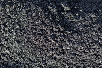 Texture of fresh hot asphalt. Black background resembling anthracite.