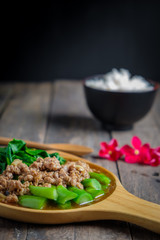 Stir fried Hong Kong kale with pork chops on a wooden table.