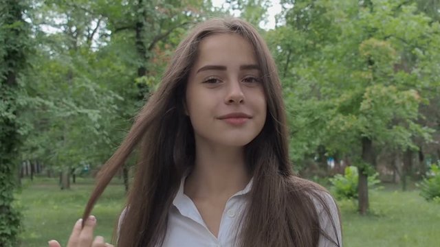 Portrait of a beautiful teenage girl. A beautiful girl straightens her hair.