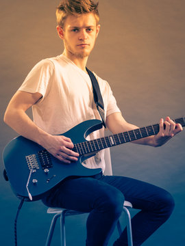 Young man playing electric guitar