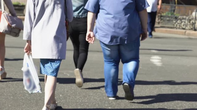 Overweight male crossing city among pedestrians, health disorder, obesity