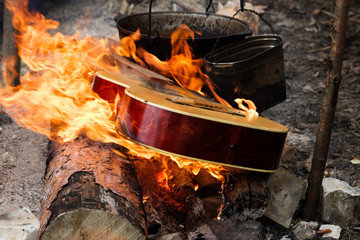 Guitar in flame and two old sooty cauldrons