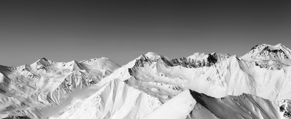 Panorama of snowy winter mountains and clear sky
