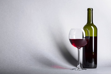 Glass and bottle of red wine.