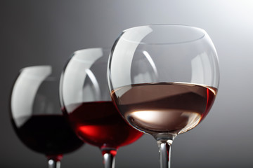 Glasses of  pink , red and white wine .