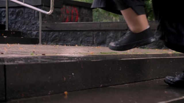 Feel Of Fat Ginger Girl With Glasses Is Alking Up Little Stairs In Park In Rainy Weather, Holding Umbrella