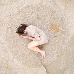 Woman lying in a stone circle. Aerial view to girl. A feminity and fertitlity concept.