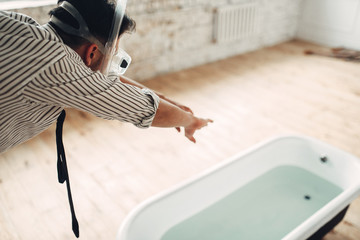 Businessman in flippers dives into the bathtub