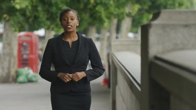 News reporter walking and talking to camera on the street