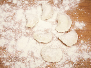 flour and dumplings on wooden board