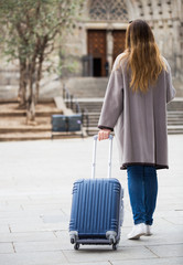 Girl taking a walk with the travel bag