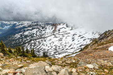 View down from the rocks and boulders on to the mountains covered with snow