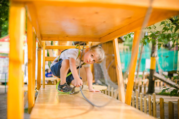 Boy climbing pass obstacles in rope park