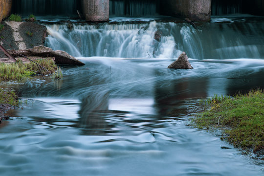 Part of the concrete structure of the river dam. Water blurred by long exposure © elcovalana