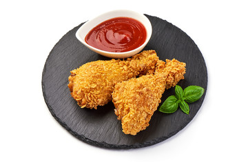 Breaded crispy fried chicken legs with ketchup, isolated on white background.