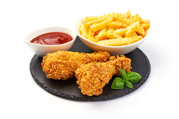 Breaded crispy chicken legs with french fries and ketchup, isolated on white background.