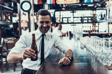 Young Happy Man Drinking Beer in Modern Bar .