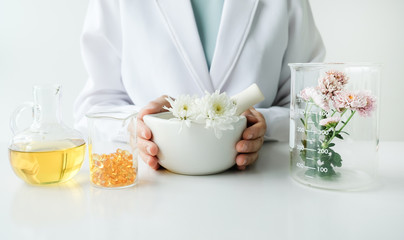 the scientist,dermatologist testing the organic natural product in the laboratory.research and development beauty skincare concept.blank package,bottle,container .cream,serum.