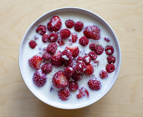 Raspberry with milk in a white bowl