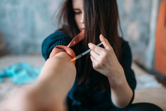 Female junkie with syringe doing an injection dose