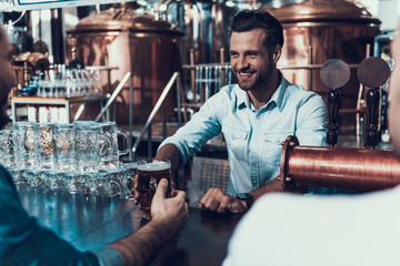Smiling Bartender Giving a Cup of Beer Modern Bar.