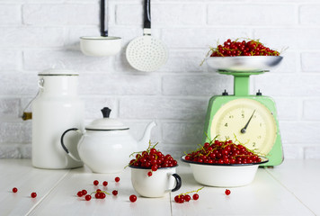Red currant berries in a cup and bowl on the kitchen table