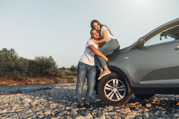 Naklejka premium Happy Couple on Roadtrip into the Sunset in SUV Car
