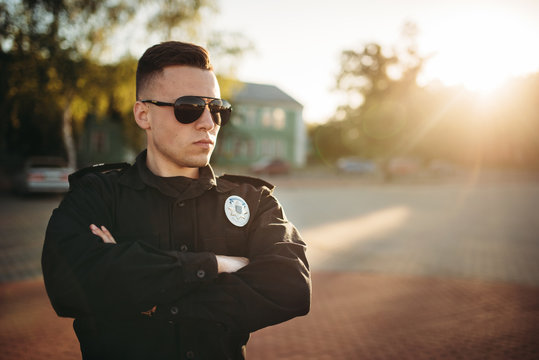 Serious male cop in uniform and sunglasses