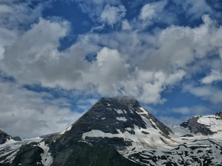 Fototapeta na wymiar Berg Hohe Dock im Juni mit Schnee in den Alpen, Himmel blau, Wolken, Sonne
