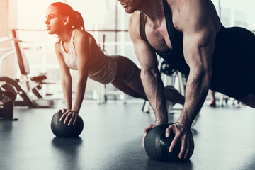 Young Man and Woman Training in Fitness Club. - obrazy, fototapety, plakaty