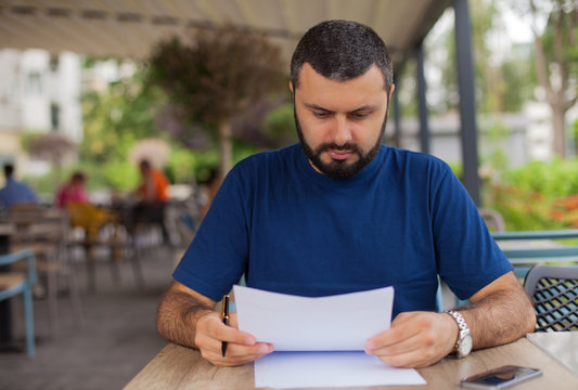 Serious Man Holding And Reading A Letter