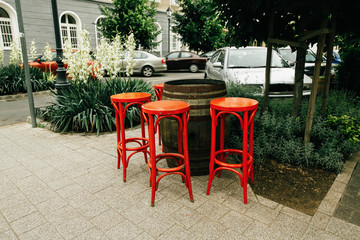 unusual red chairs and wooden barrel, setting in street cafe, creative service in Budapest city,...