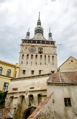 Fototapeta na wymiar Clock Tower in Sighisoara with many old buildings in this beautiful world heritage site in Romania