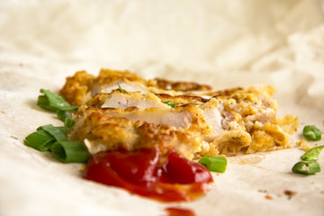Fresh fried pork chops sprinkled with green onions and ketchup.  Arrangement  on the wrapping paper