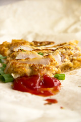 Fresh fried pork chops sprinkled with green onions and ketchup.  Arrangement  on the wrapping paper