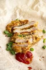 Fresh fried pork chops sprinkled with green onions and ketchup.  Arrangement  on the wrapping paper