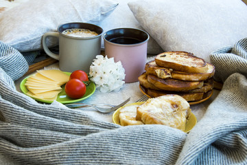 Delicious breakfast in bed with toast and a big cup of coffee