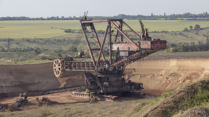 Fototapeta premium The operating machines in the quarry for the extraction of manganese ore