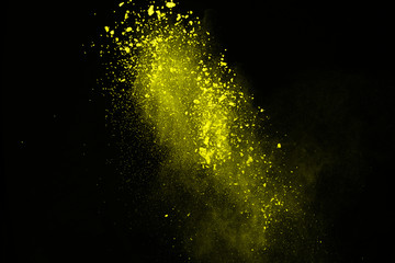 Fototapeta na wymiar Explosion of yellow powder on black background.