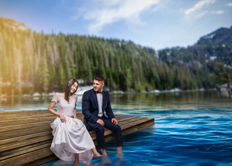 Bride and groom sit on the pier, romantic scene