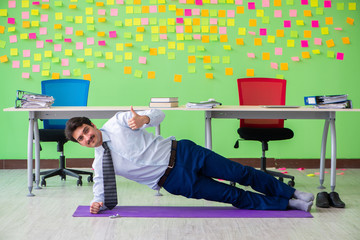 Man in the office with many conflicting priorities doing exercis