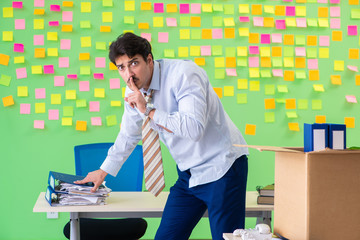 Man collecting his stuff after redundancy in the office with man