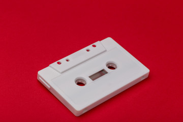white audio cassette on red background