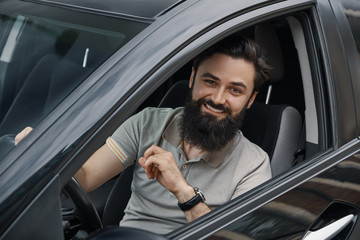 Young man smiling while driving a car