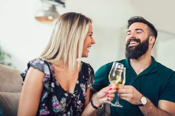 Smiling couple dating and drinking wine at home