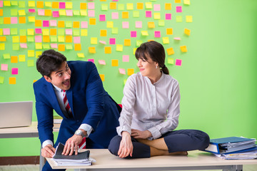 Man and woman in the office with many conflicting priorities in 
